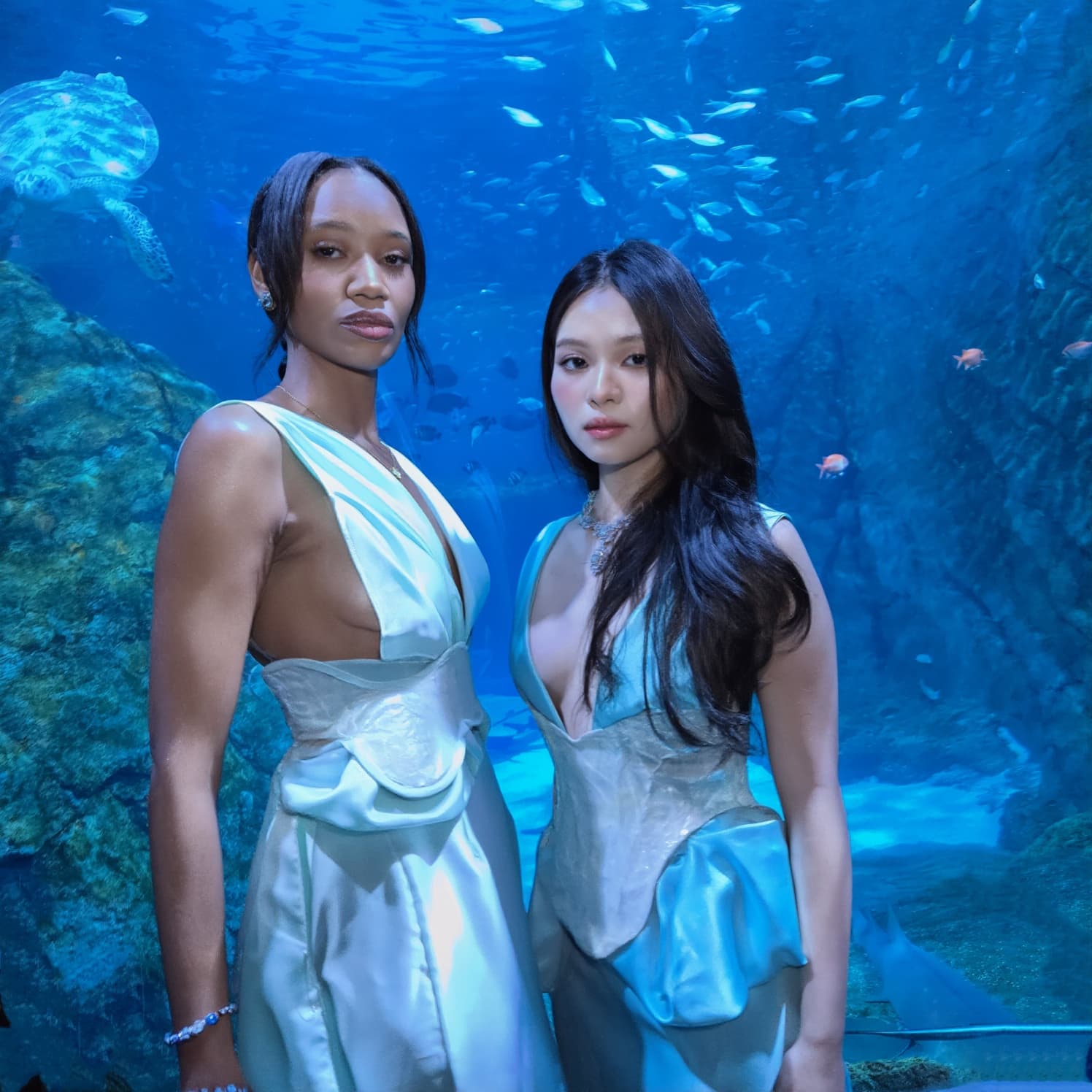 2 models in light blue and seafoam dress looking like mermaids wearing mother-of-pearl corsets underwater